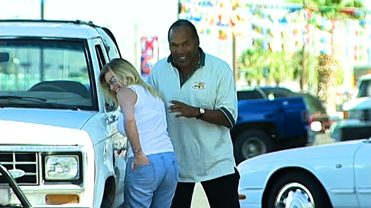 A woman laughing by a white bronco as OJ Simpsons stands next to her from OJ Unseen
