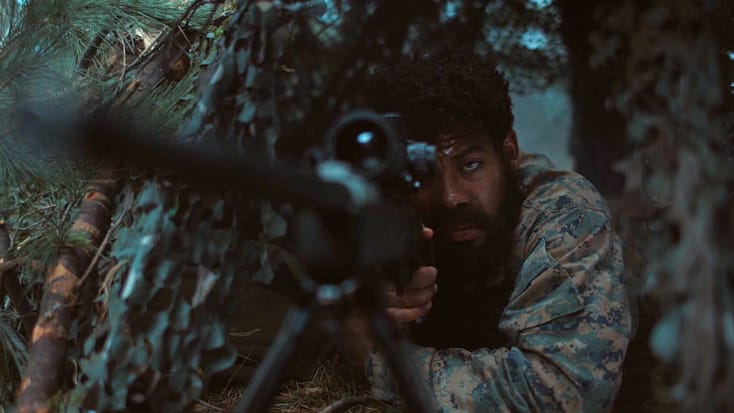 John Stewart in a hutch aiming his sniper rifle 2 from Lanterns